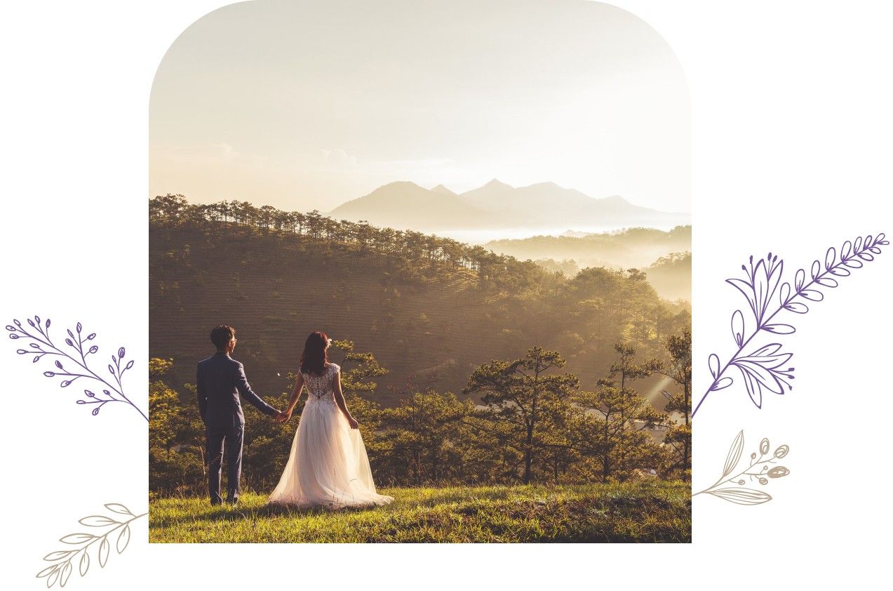 Couple holding hands on their wedding day, overlooking mountains in the distance